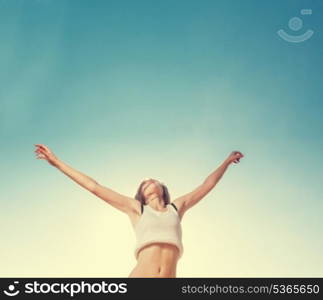 Women and a lot of a sky for copyspace. Blonde teenager girl jumping happy with the blue sky in the background