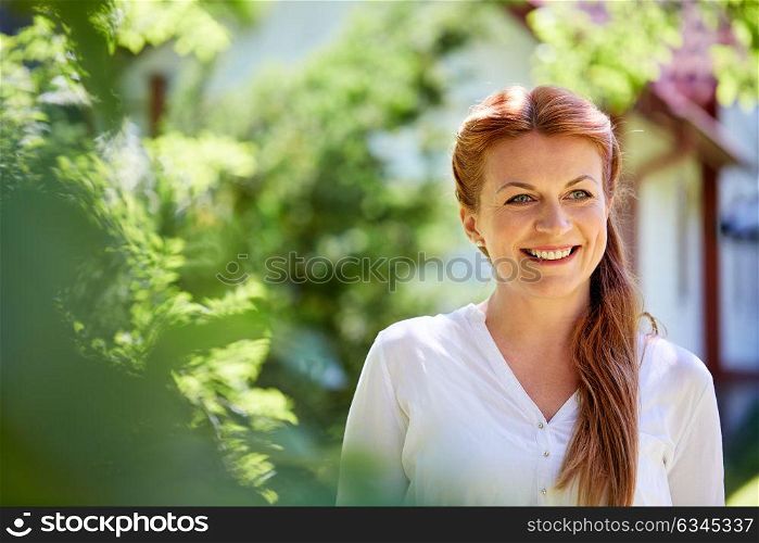 women and people concept - happy smiling woman at summer garden. happy smiling woman at summer garden