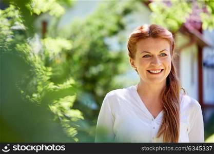 women and people concept - happy smiling woman at summer garden. happy smiling woman at summer garden