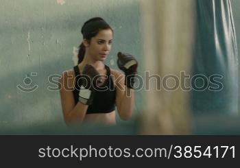 Women and sport, beautiful young female athlete exercising in boxing gym. Dolly shot