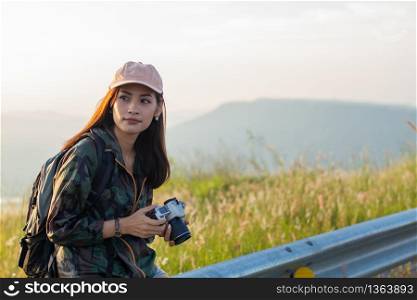 women asian with backpack taking a photo on view at sunrise seaside mountain peak
