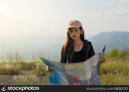 women asian with bright backpack looking at a map. View from back of the tourist traveler on background mountain