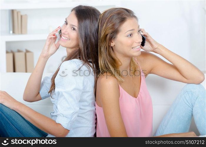 Women back to back using their cellphones
