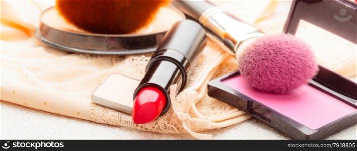 Women beauty concept. Makeup supplies various cosmetics. Red lipstick, poudre and rouse cheeks on lace langerie.