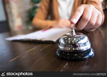 Women call hotel reception with finger push a bell in lobby hotel. hotel concept.