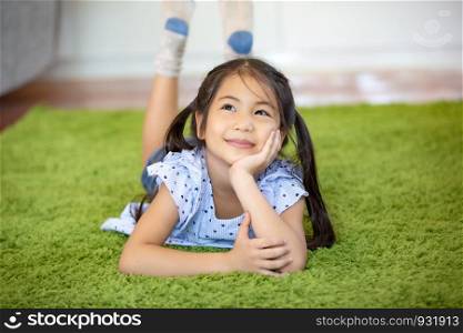 women children lying on green mate thinking by look away from camera