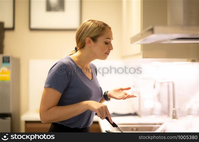women cooking food on pan in kitchen