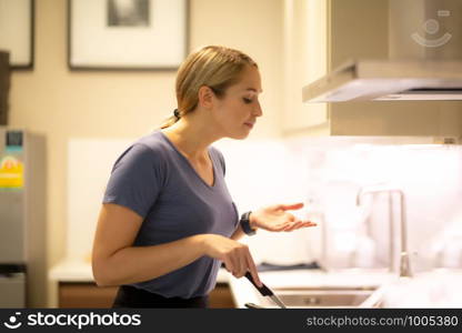 women cooking food on pan in kitchen