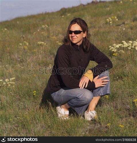 Women crouching in field