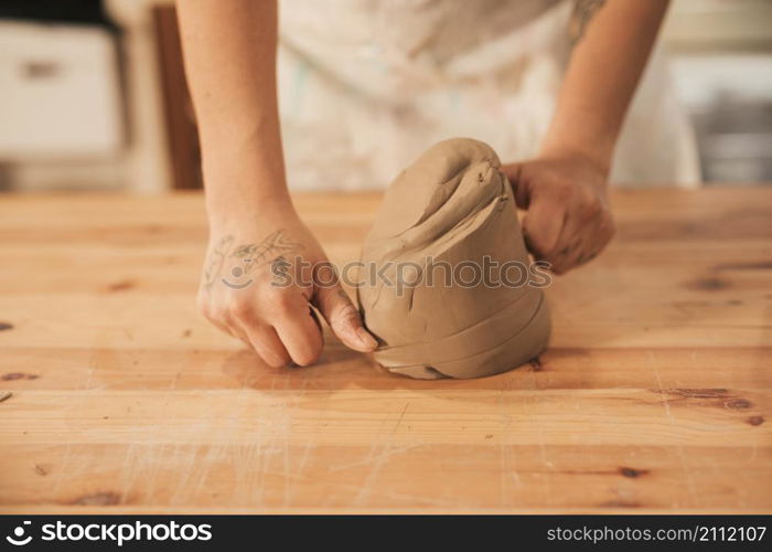 women cutting clay with thread wooden table