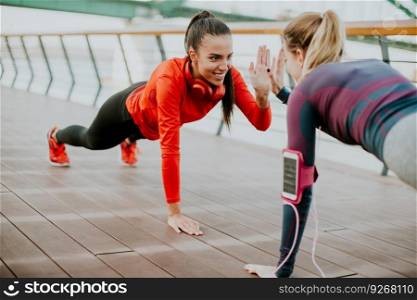 Women doing plank on riverside after running