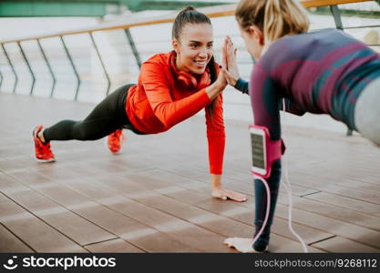 Women doing plank on riverside after running