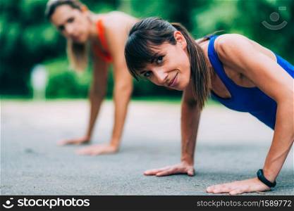 Women doing push-ups in the park