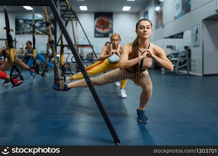 Women doing stretching exercise in gym. People on fitness workout in sport club, athletic girls in sportswear on training indoors. Women doing stretching exercise in gym