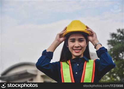 Women Engineering touching on hard hat safety standing outdoor work place