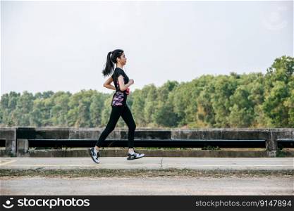 Women exercise by running on the road on the bridge.