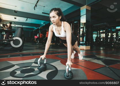 Women exercising by pushing the floor with the Kettlebell in the gym.