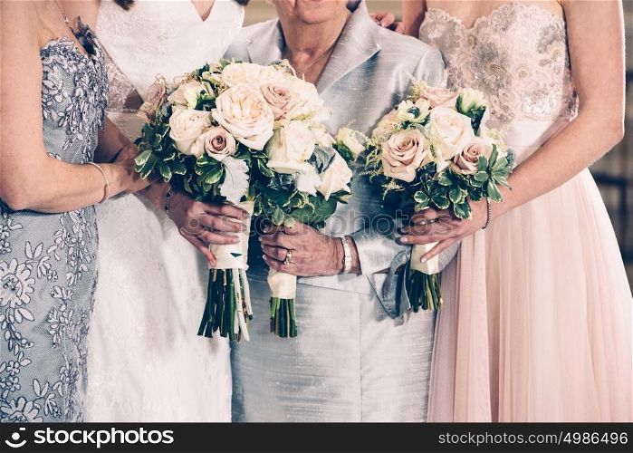 Women generation family and bride holding flowers bunches on wedding day.