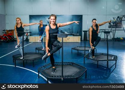 Women group doing fit exercise on sport trampoline, fitness workout. Female teamwork in gym. Aerobic class. Women group doing fit exercise on sport trampoline