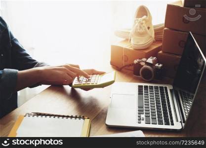Women hand doing finances and calculate on desk about cost at home office, Online selling e-commerce shipping idea concept freelance start up small business owner
