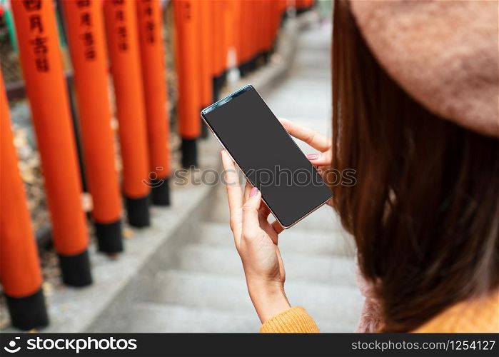 Women hand holding smart phone with blank screen for copy space, close up, Japanese style background.