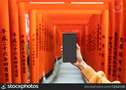 Women hand holding smart phone with blank screen for copy space, close up, Japanese style background.