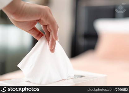 women hand picking napkin/tissue paper from the tissue box