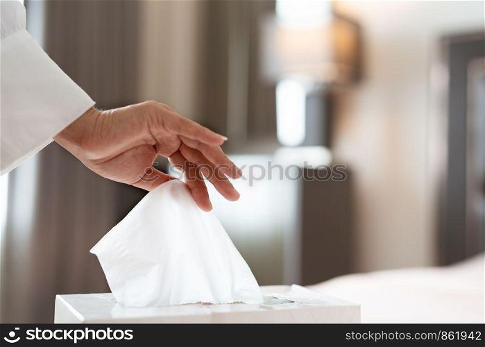 women hand picking napkin/tissue paper from the tissue box