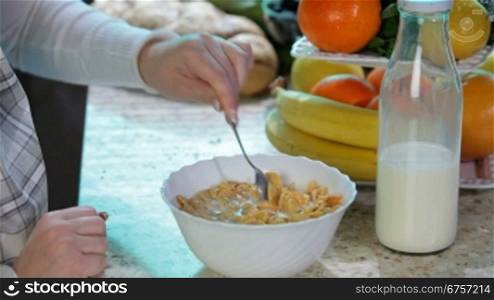 Women hands are preparing cereal with milk for breakfast