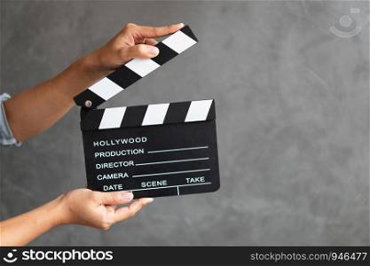Women hands holding clapper board for making video cinema in studio.