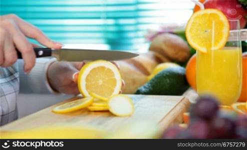 Women hands sliced lemon on chopping board