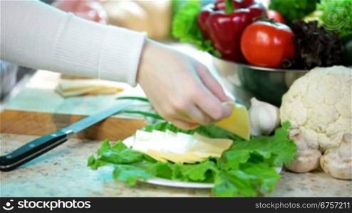 women hands slicing the cheese on the kitchen table