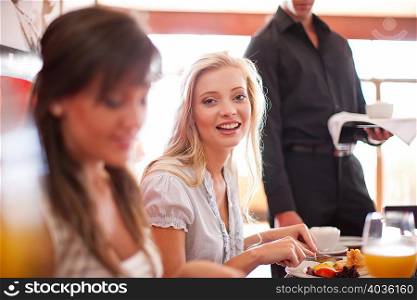 Women having breakfast together in cafe