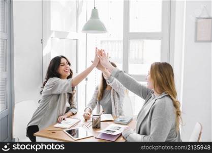 women high fiving table