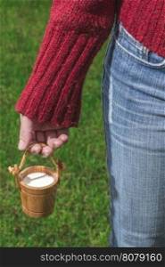 Women hold small wooden mug of milk