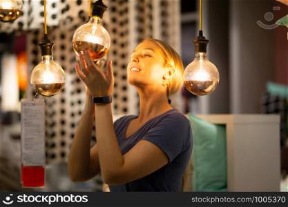 women holding and looking at bulb light reflected on her face