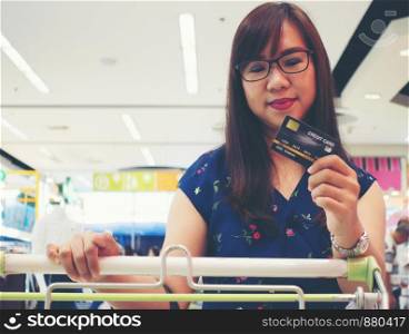Women holding credit cards and shopping cart, shopping concept