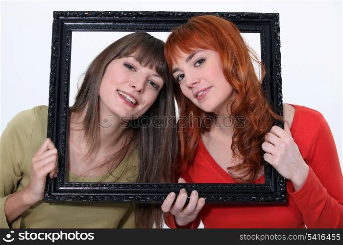 Women holding wooden frame