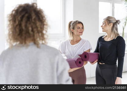 women holding yoga mats