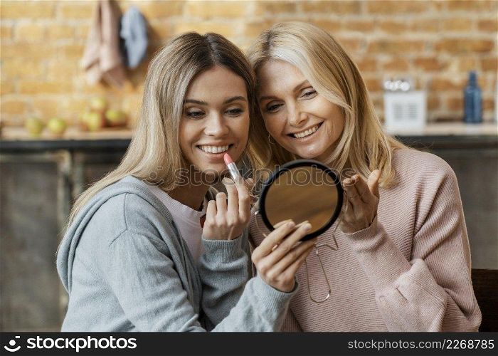 women home putting lipstick together