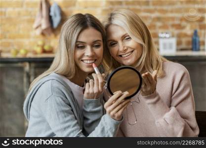 women home putting lipstick together