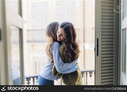 women hugging balcony