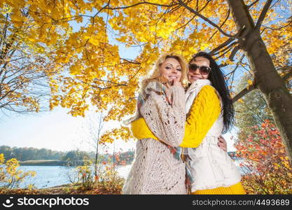 Women in autumn park. Two cheerful women in autumn park at sunny day