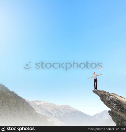 Women in business. Risky businesswoman standing on edge of rock