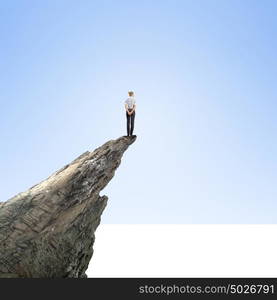 Women in business. Risky businesswoman standing on edge of rock