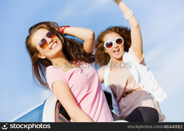 Women in car. Young pretty women leaning out of car window