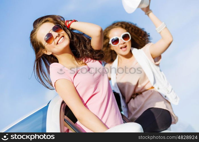 Women in car. Young pretty women leaning out of car window