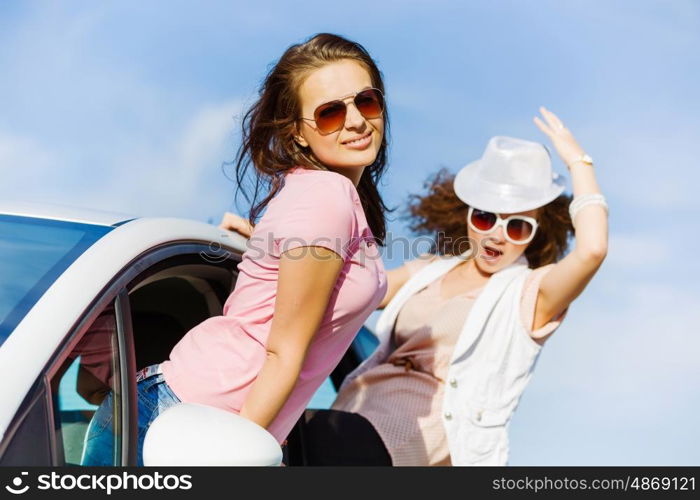 Women in car. Young pretty women leaning out of car window