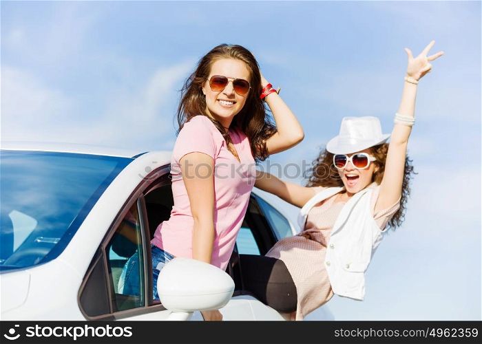 Women in car. Young pretty women leaning out of car window