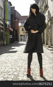 Women in grey wool jacket on a street. Sunlight